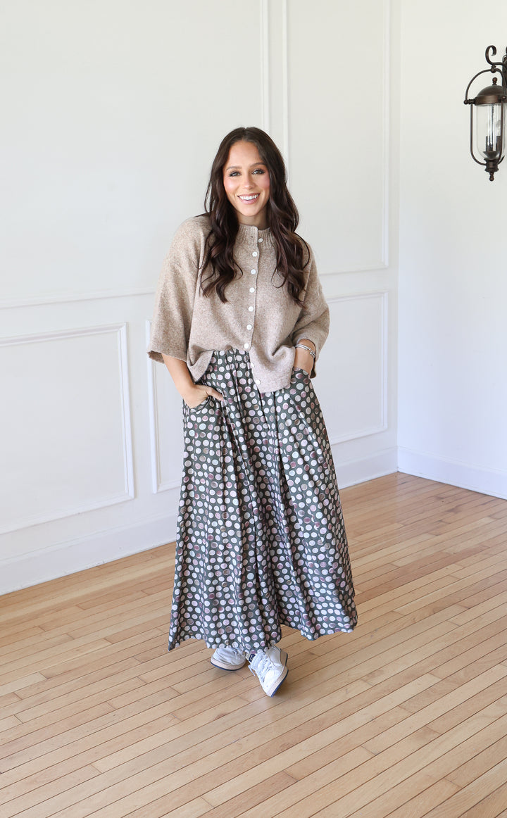 Woman wearing Olive Dot Maxi Skirt with cream cardigan