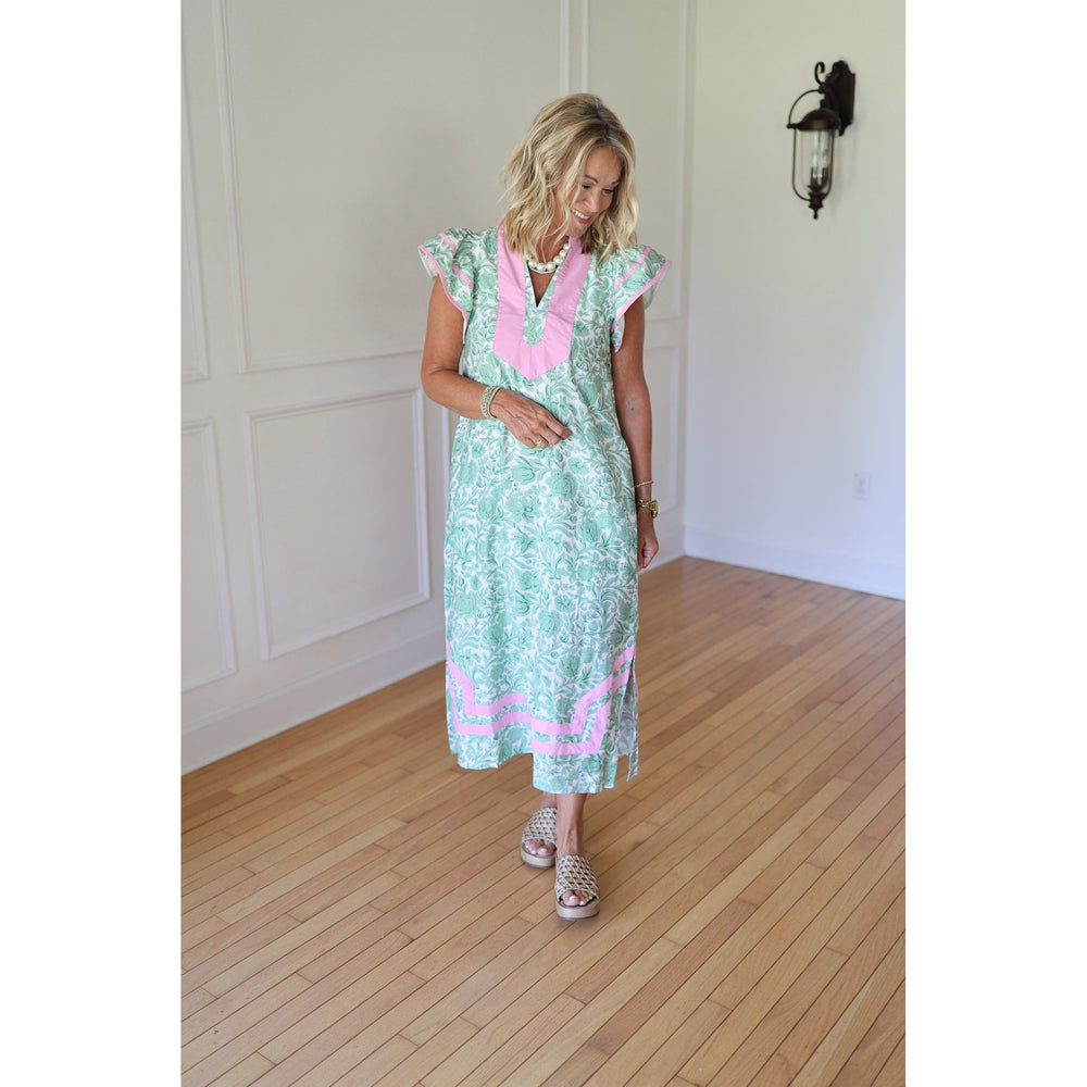 Woman wearing a green dress with pink accents 
