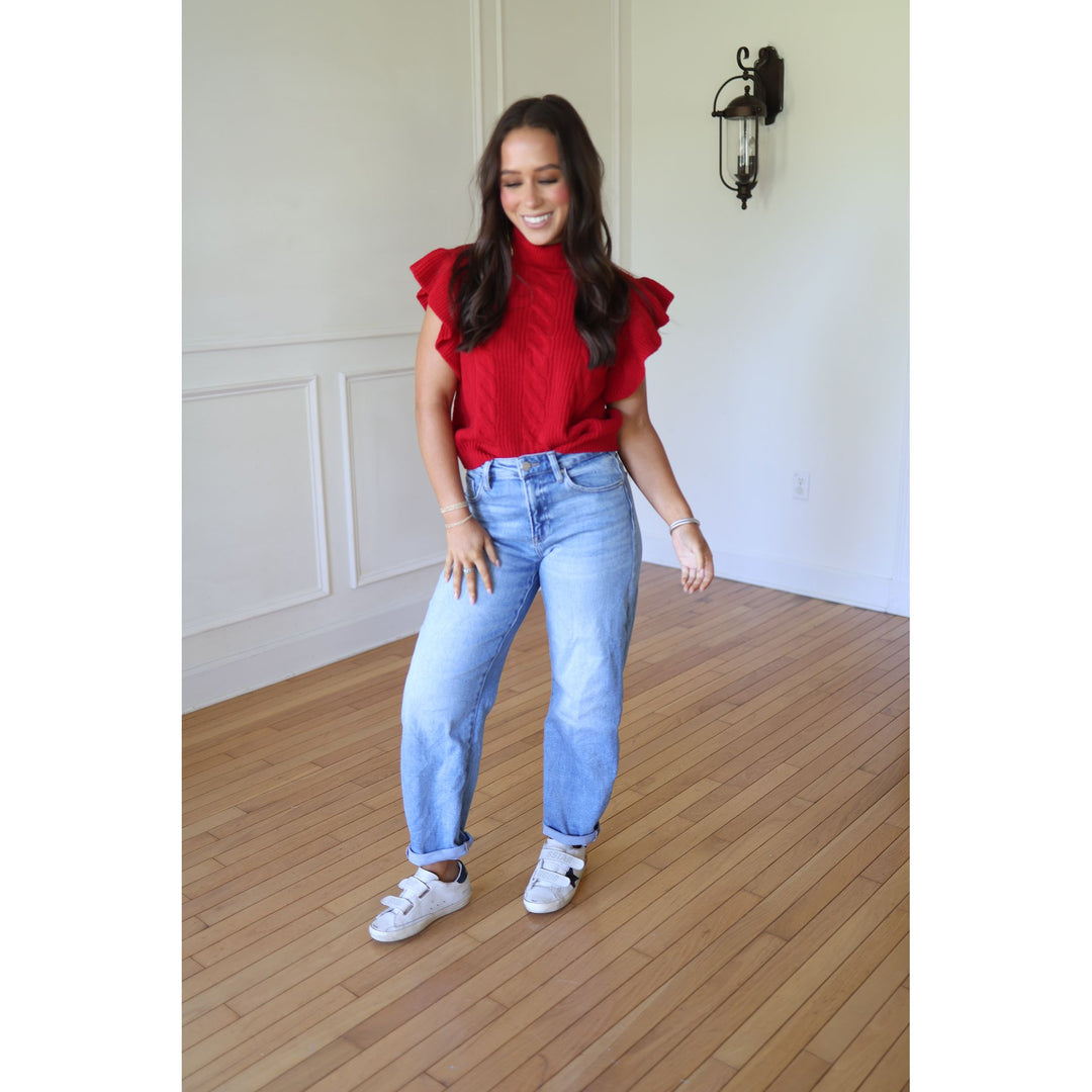 Woman wearing a red top and blue jeans 
