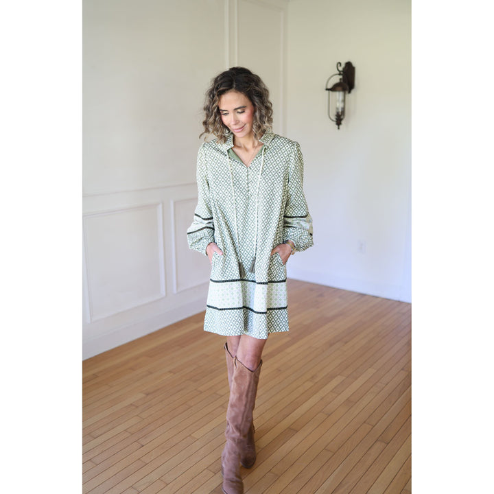 Woman wearing a patterned dress and knee-high boots 