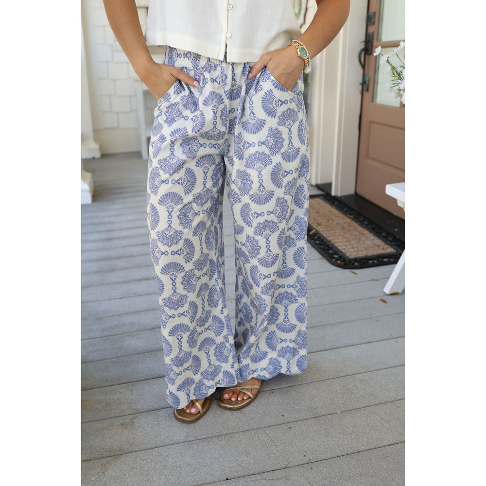 Person wearing blue and white patterned pants on a wooden deck.