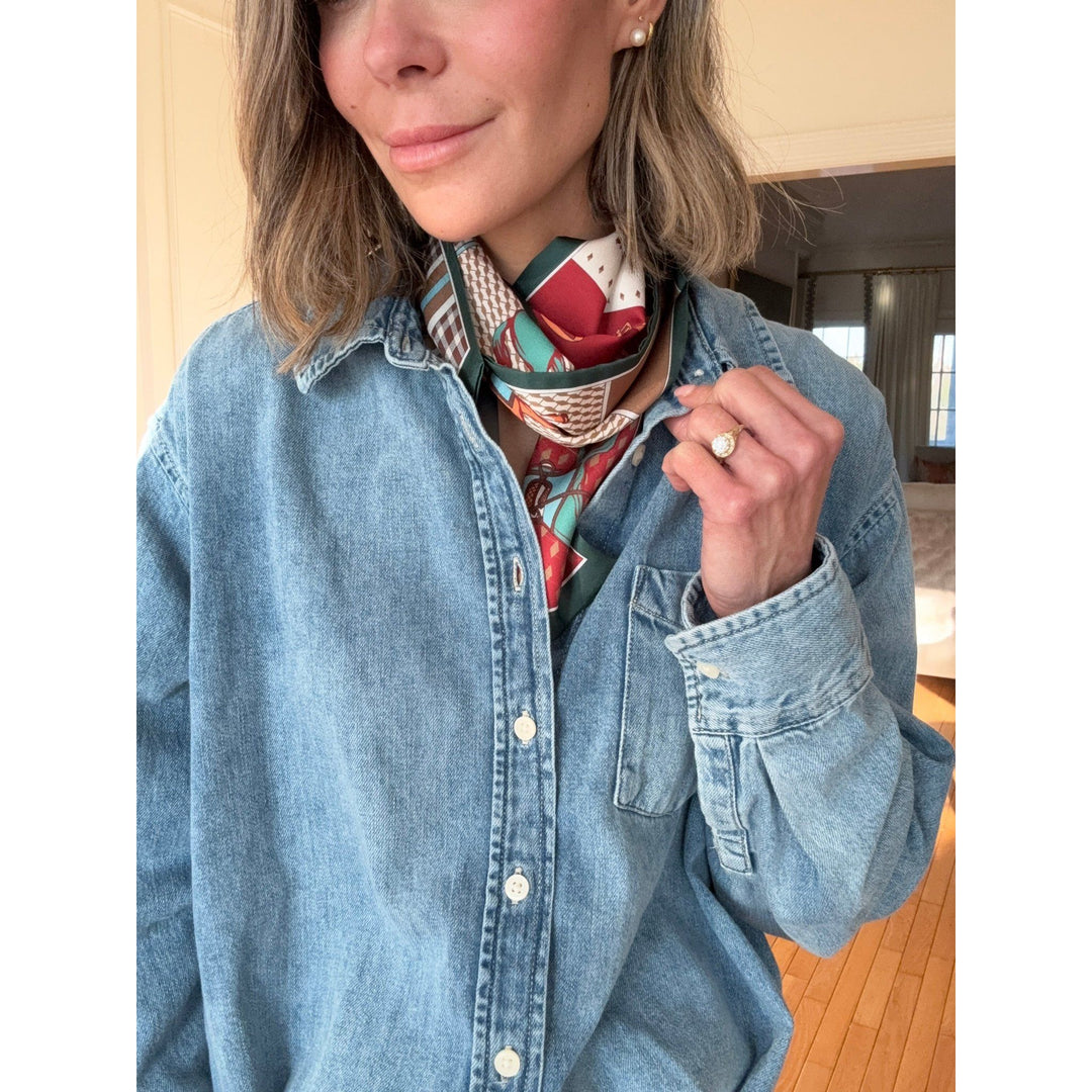 Person wearing a colorful scarf around their neck with a denim jacket.