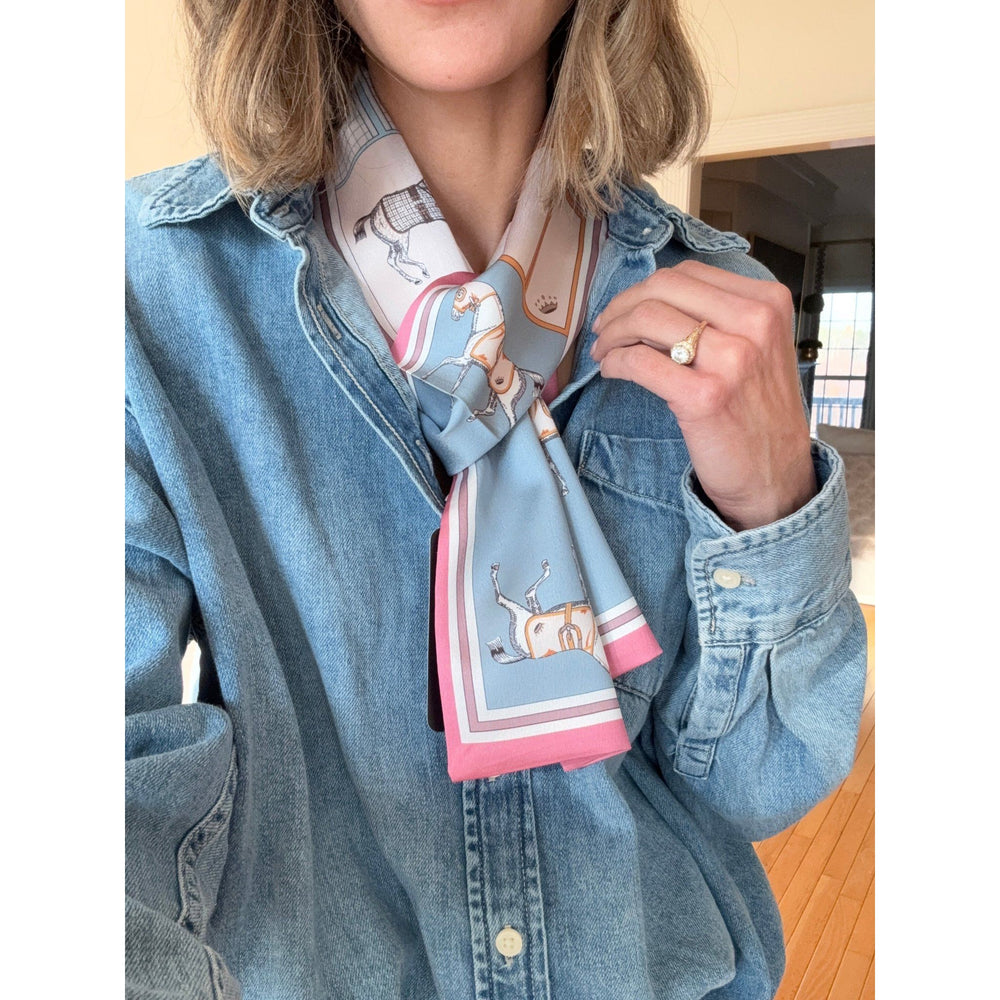 Person wearing a blue denim jacket with a pink patterned scarf around their neck.