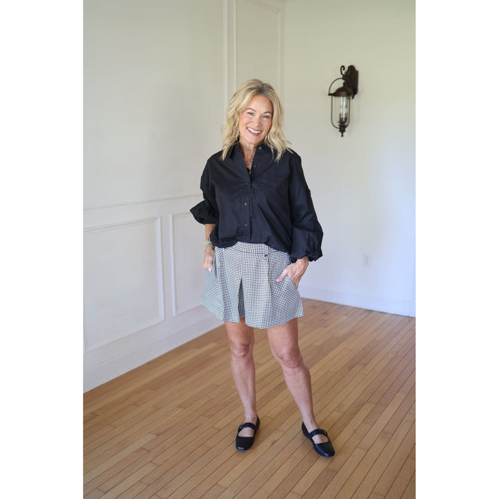 Woman wearing a black shirt and checkered shorts 