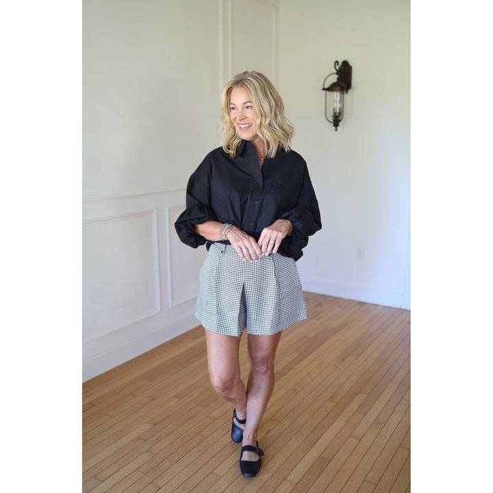 Woman wearing a black shirt and checkered shorts 