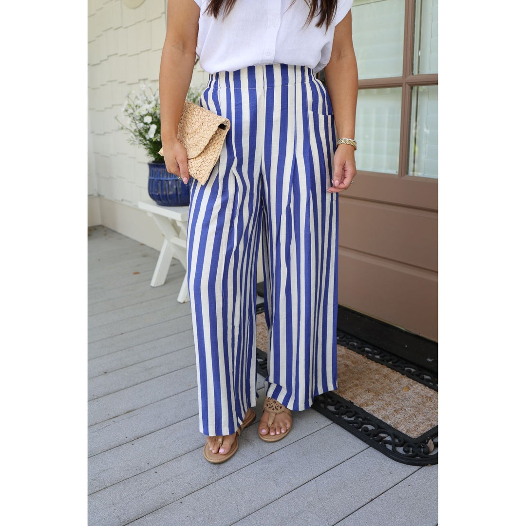 Person wearing blue and white striped pants on a porch