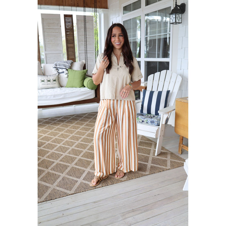 woman wearing brown striped pants and cream top