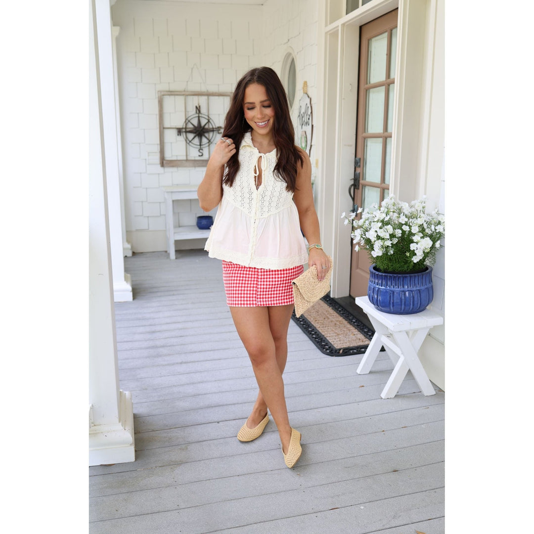 woman in red gingham skirt and cream top