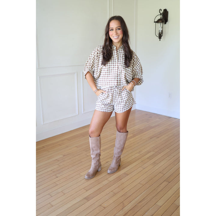 Woman wearing a checkered outfit with knee-high boots 