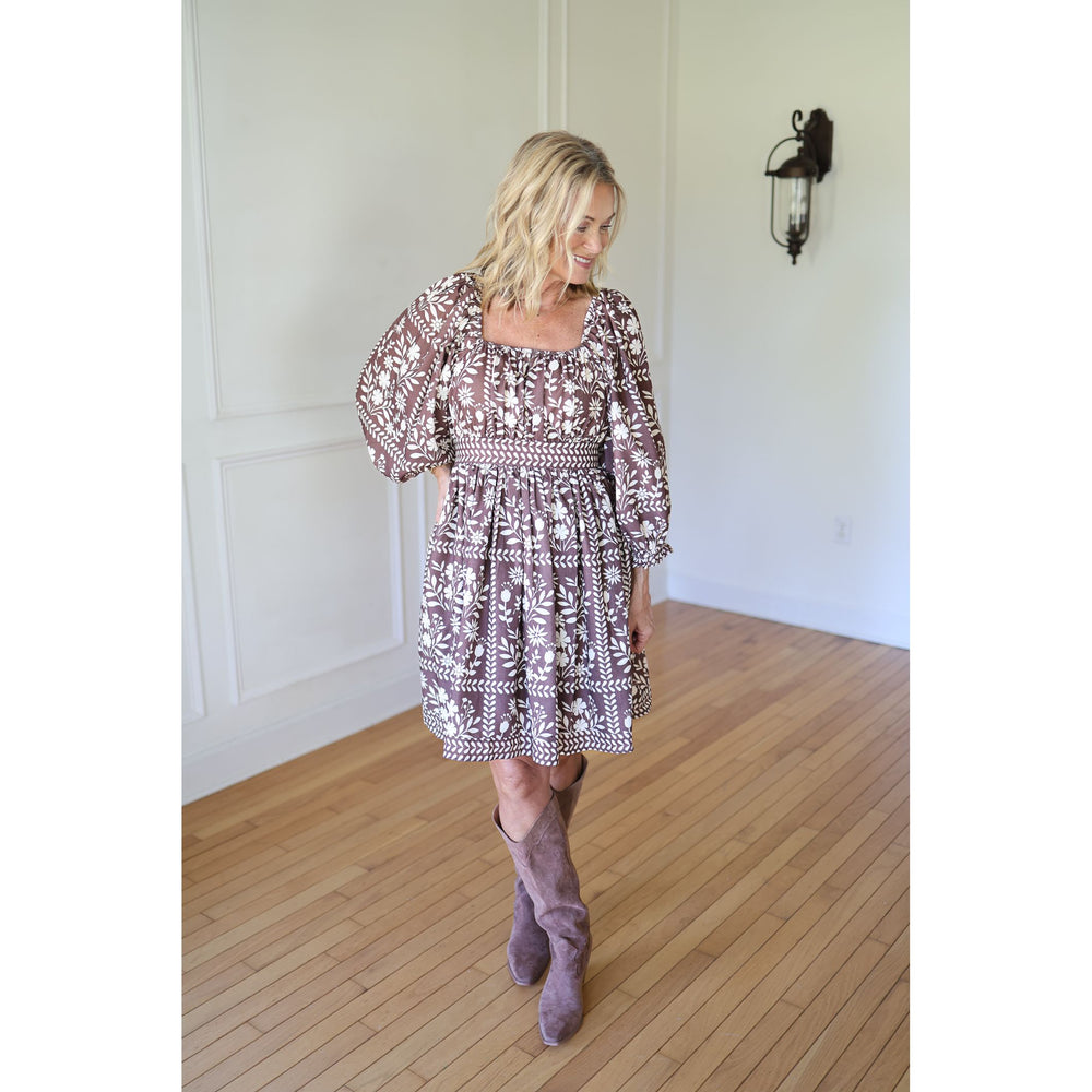 Woman wearing a patterned dress and high boots 