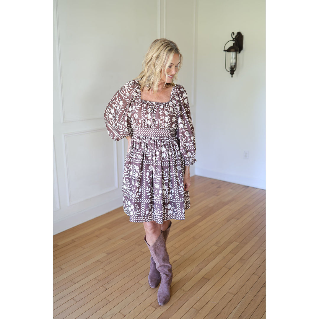 Woman wearing a patterned dress and high boots 