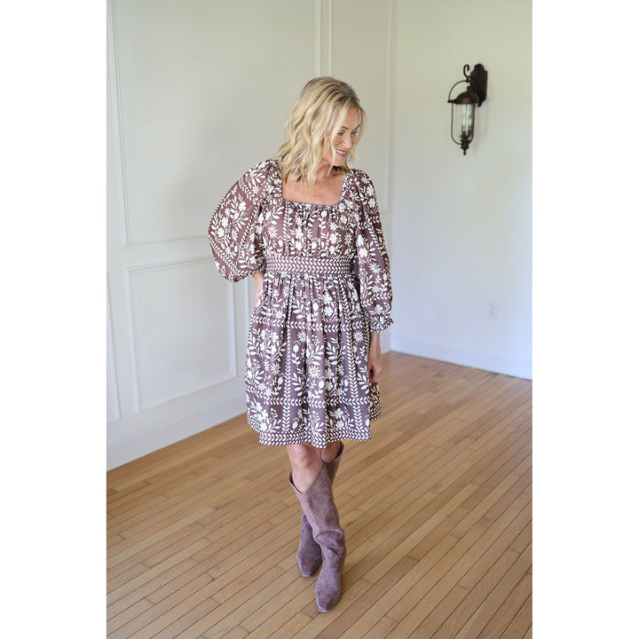 Woman wearing a patterned dress and high boots 