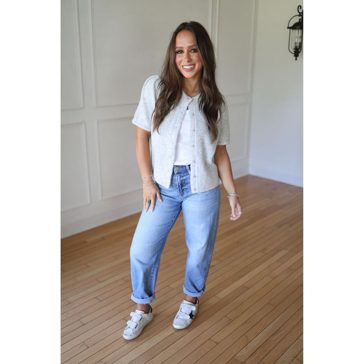 Woman wearing a gray cardigan and blue jeans 