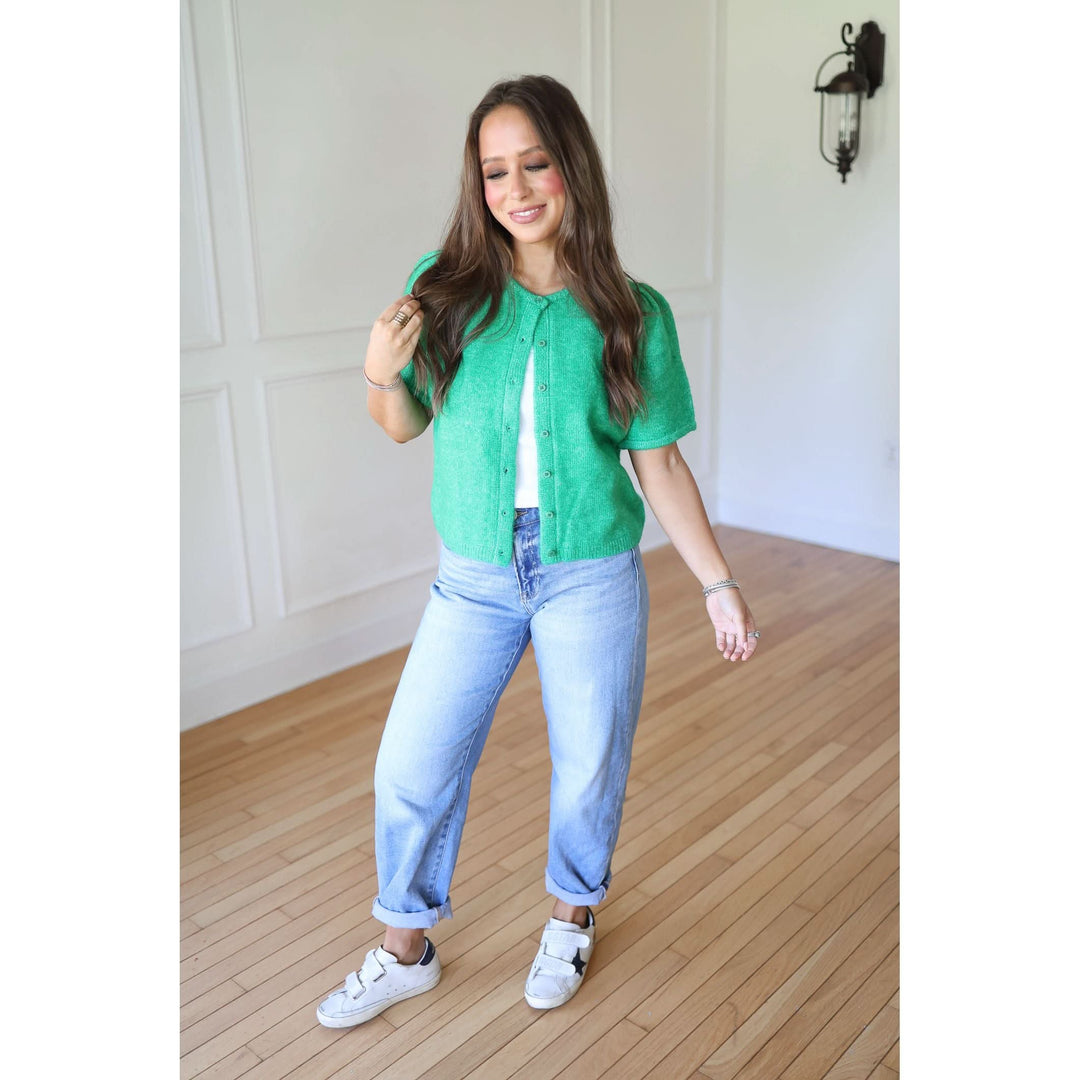 Woman wearing a green shirt and blue jeans 
