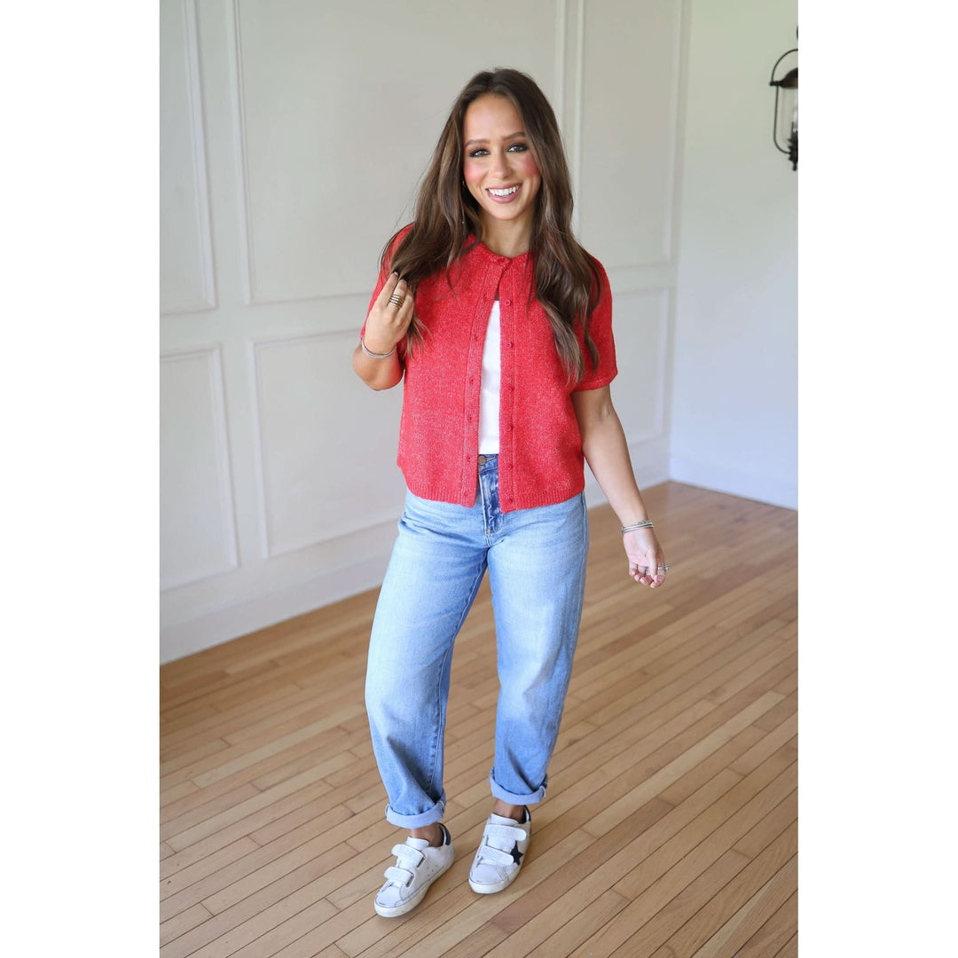 Woman wearing a red shirt and blue jeans 