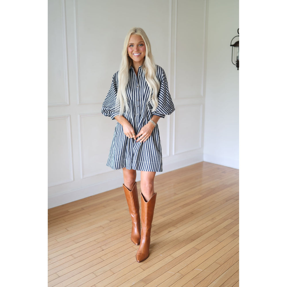 Woman wearing a striped dress and brown boots 