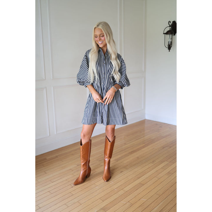 Woman wearing a striped dress and brown boots 