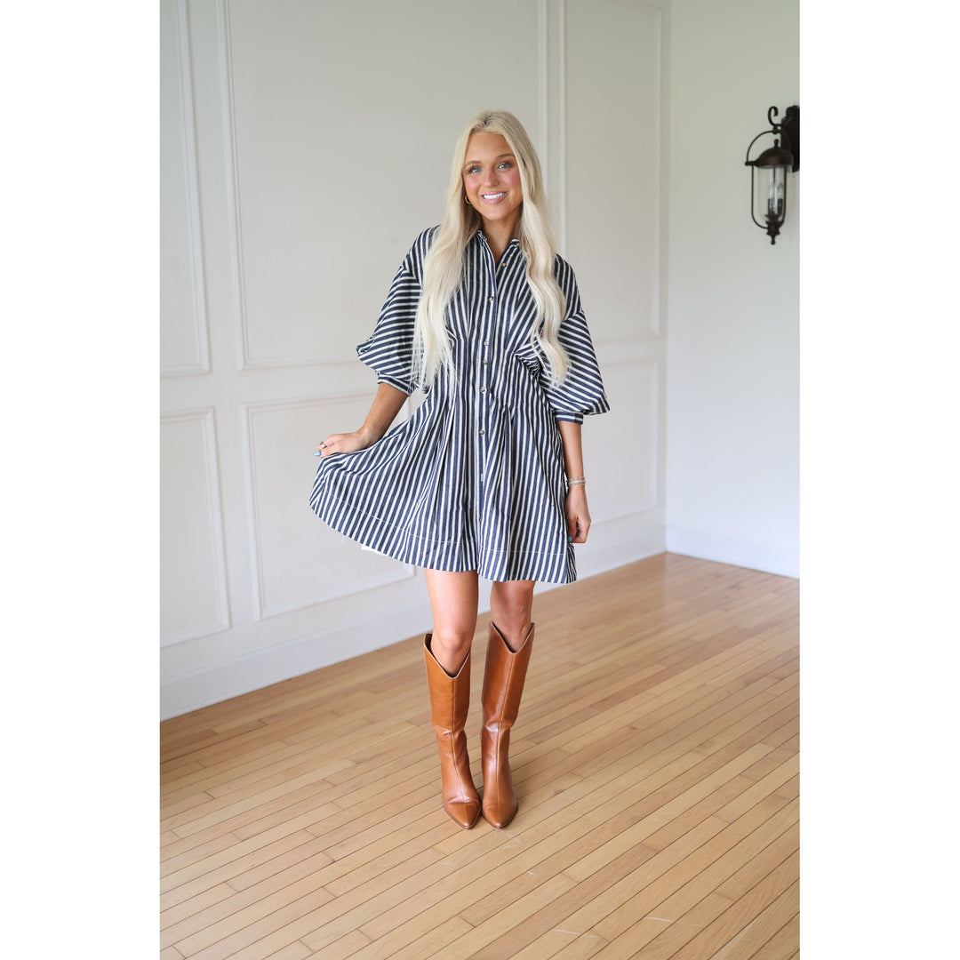 Woman wearing a striped dress and brown boots 