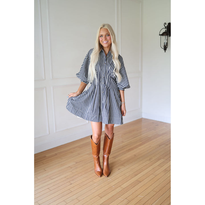 Woman wearing a striped dress and brown boots 