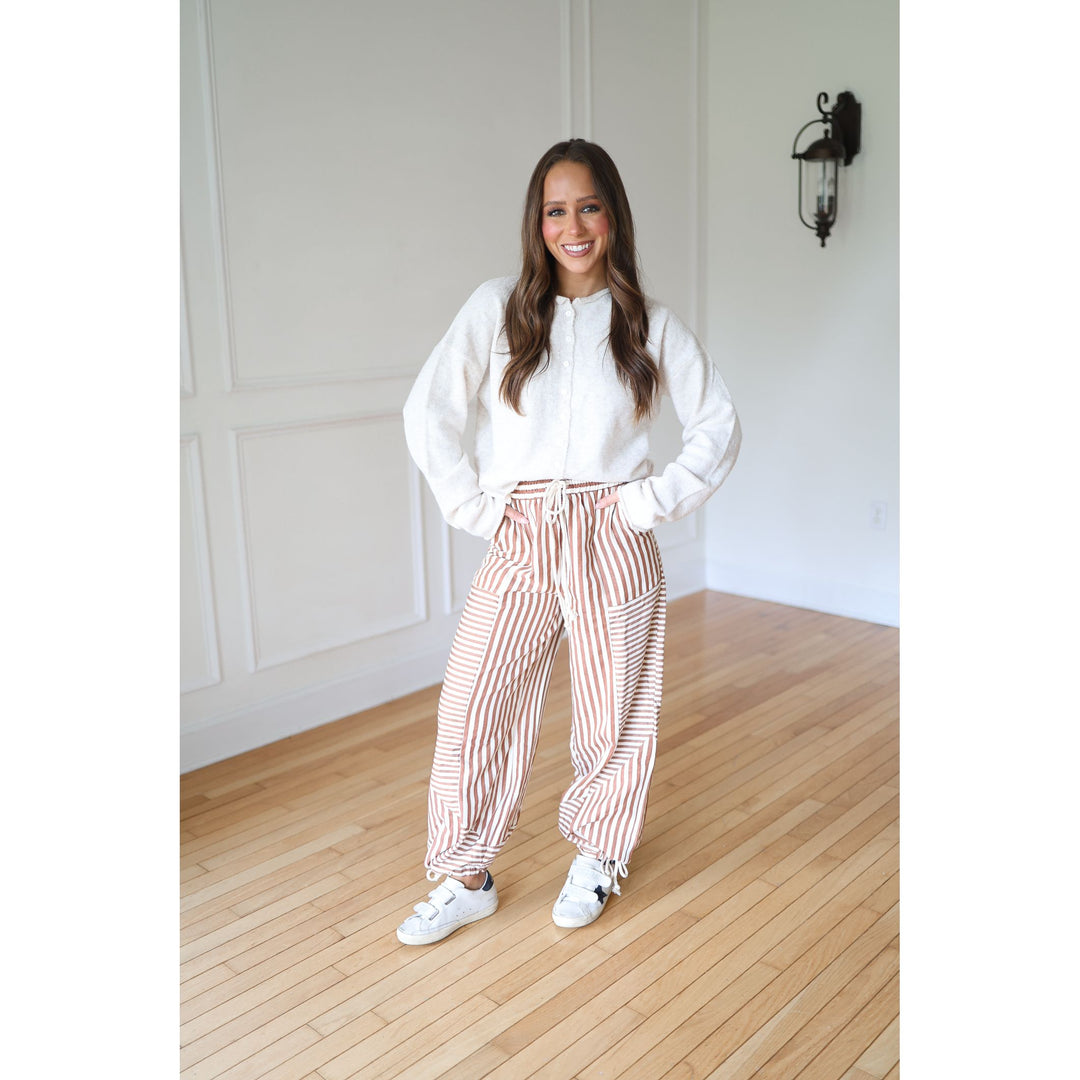 Woman wearing a white top and striped pants 