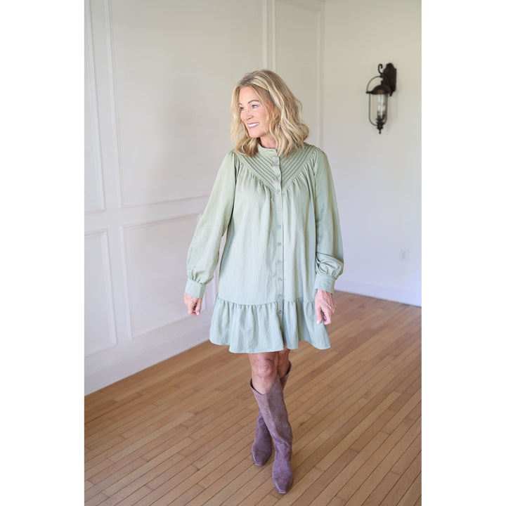 Woman wearing a light green dress with long sleeves 