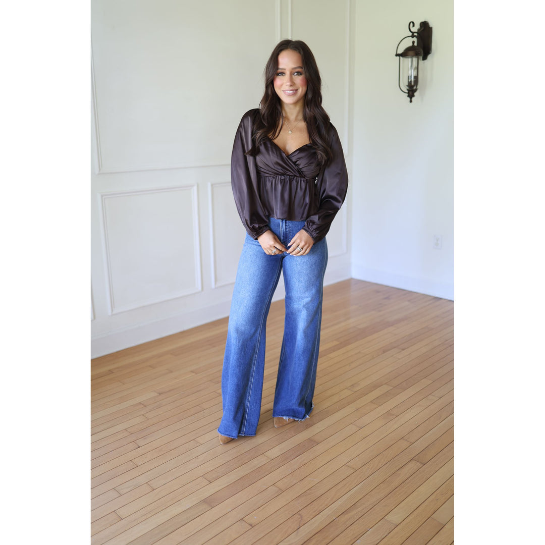 Woman wearing a dark blouse and blue jeans 