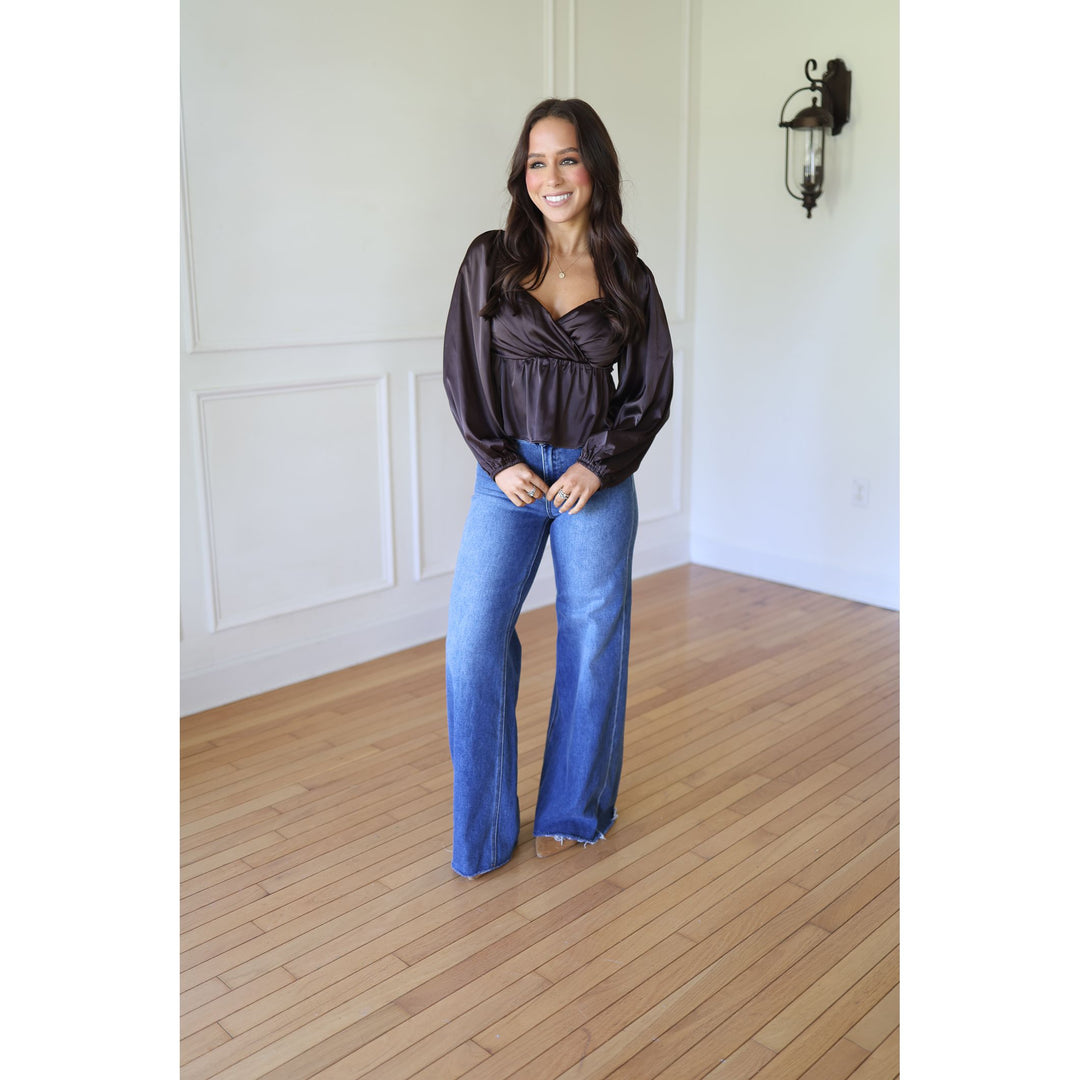 Woman wearing a dark blouse and blue jeans 