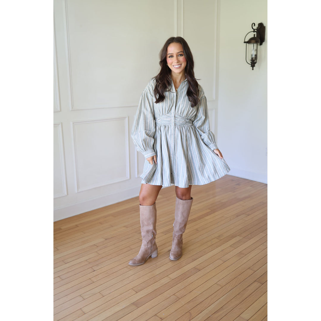 Woman in a light-colored dress and knee-high boots s