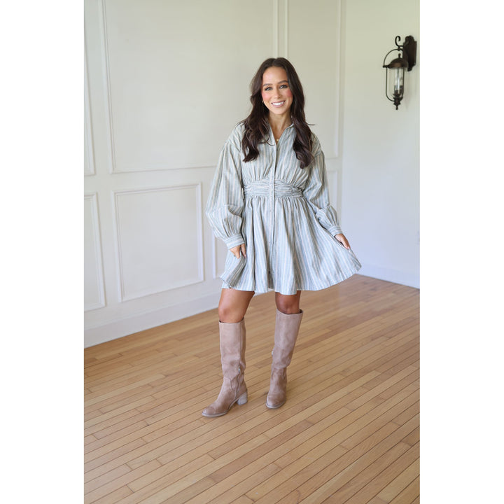 Woman in a light-colored dress and knee-high boots s