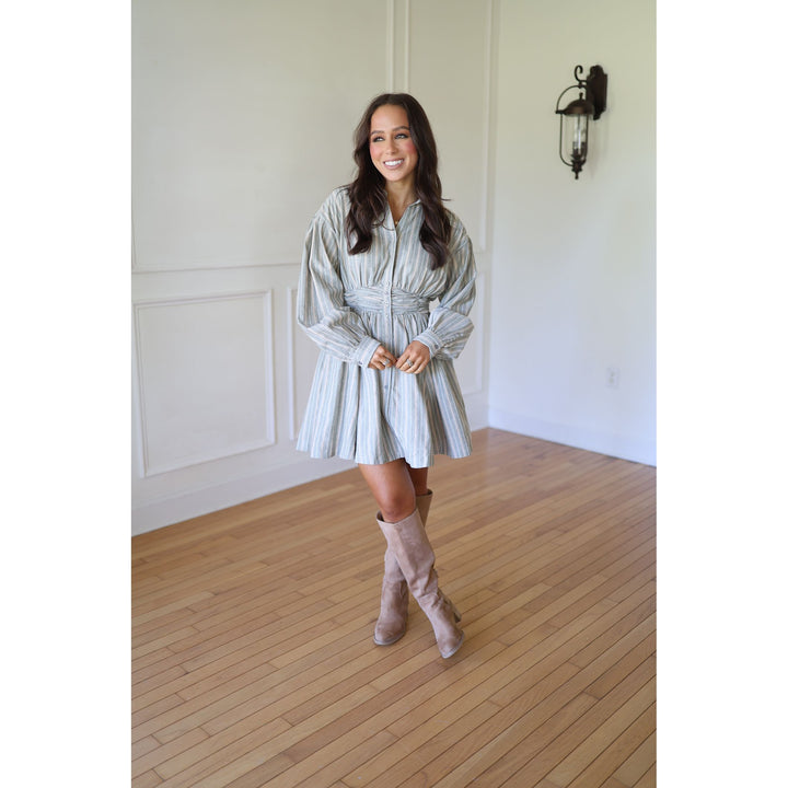 Woman in a striped dress and beige boots 