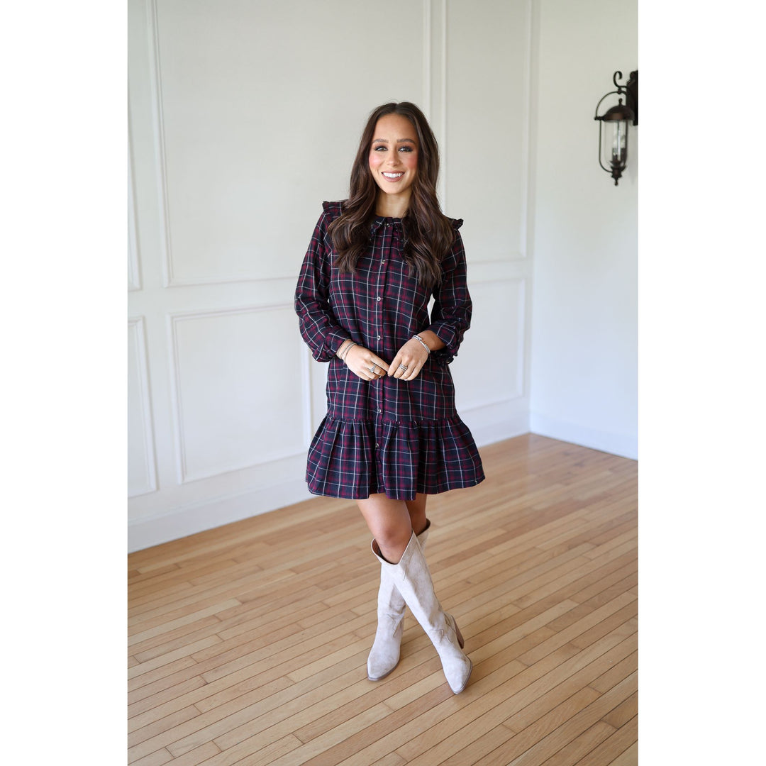 Woman wearing a plaid dress and white boots 