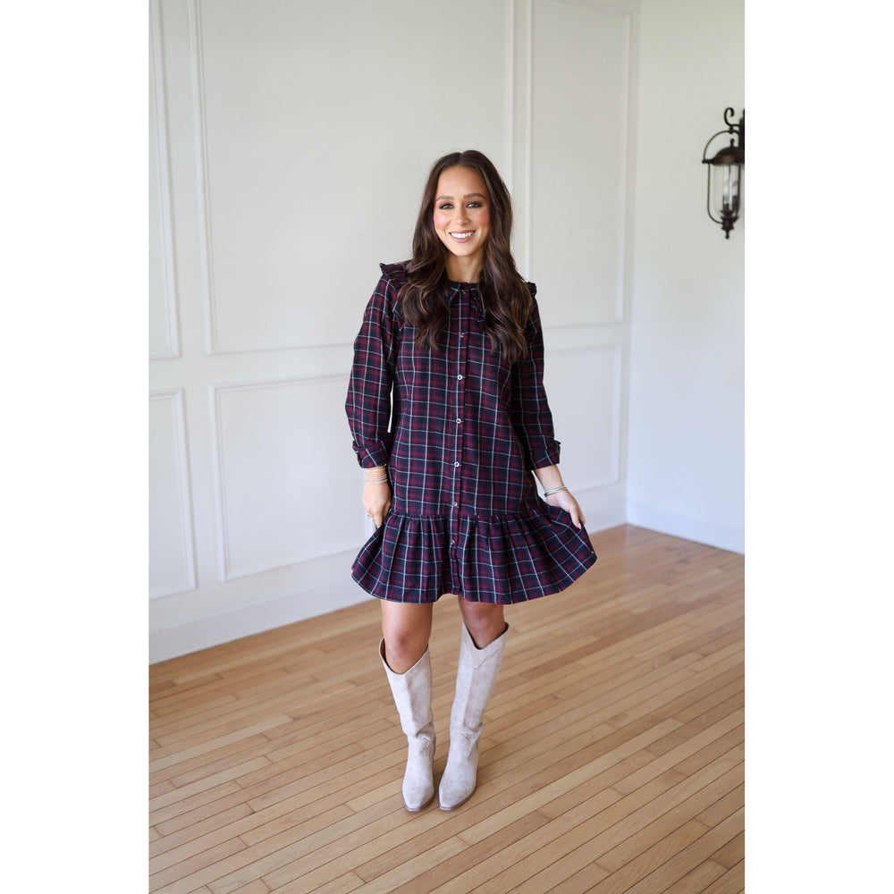 Woman wearing a plaid dress and white boots 