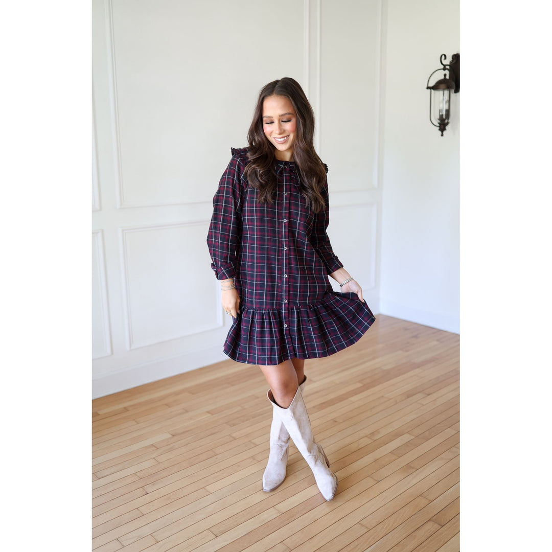 Woman wearing a plaid dress with white boots 