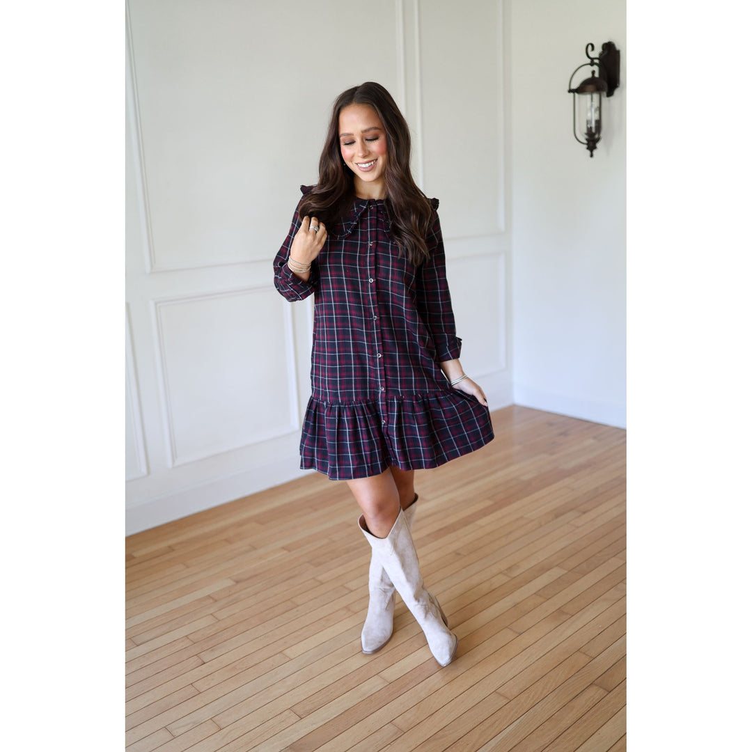 Woman wearing a plaid dress with white knee-high boots 