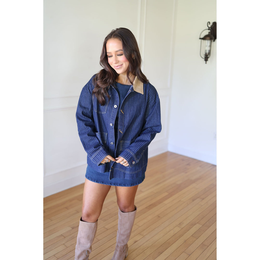 Woman wearing a blue jacket and skirt with beige boots 