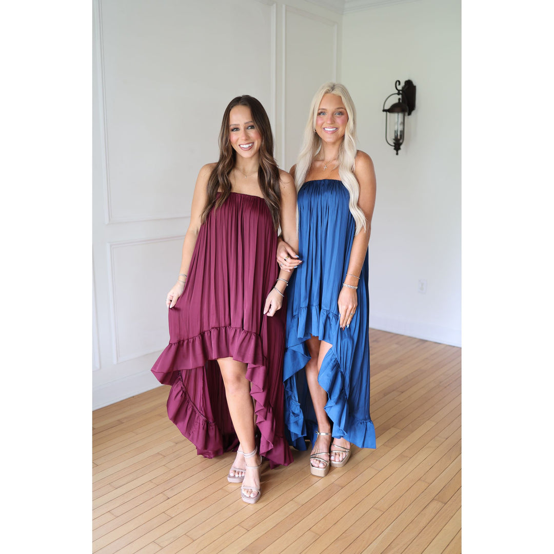 Two women wearing strapless dresses, one purple and one blue