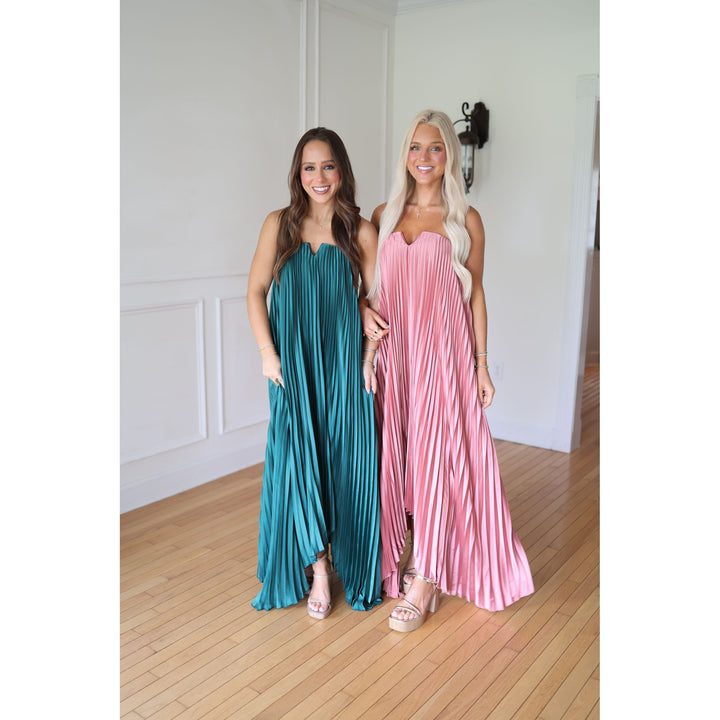 Two women wearing pleated dresses 