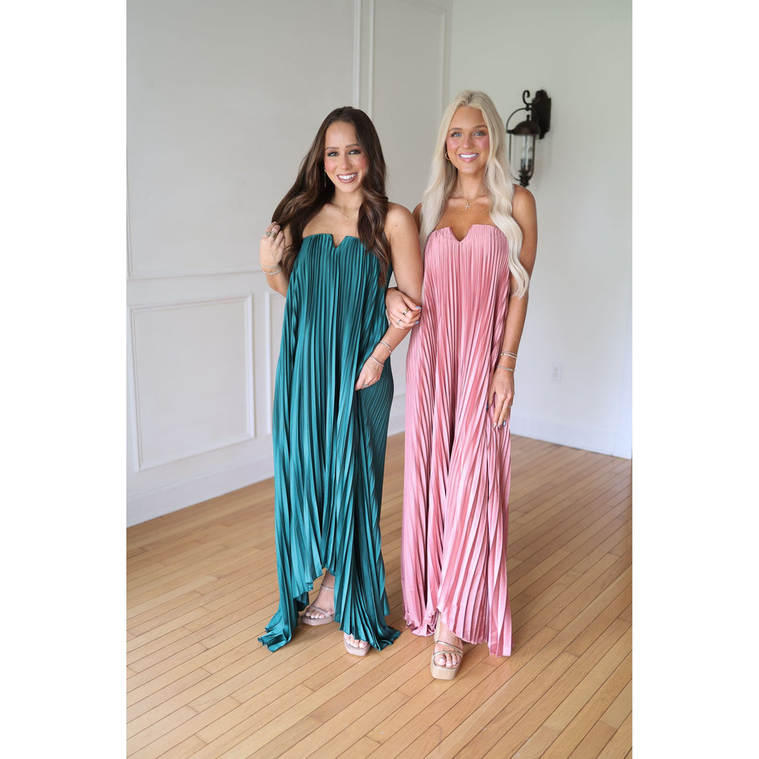 Two women wearing strapless dresses, one teal and one pink