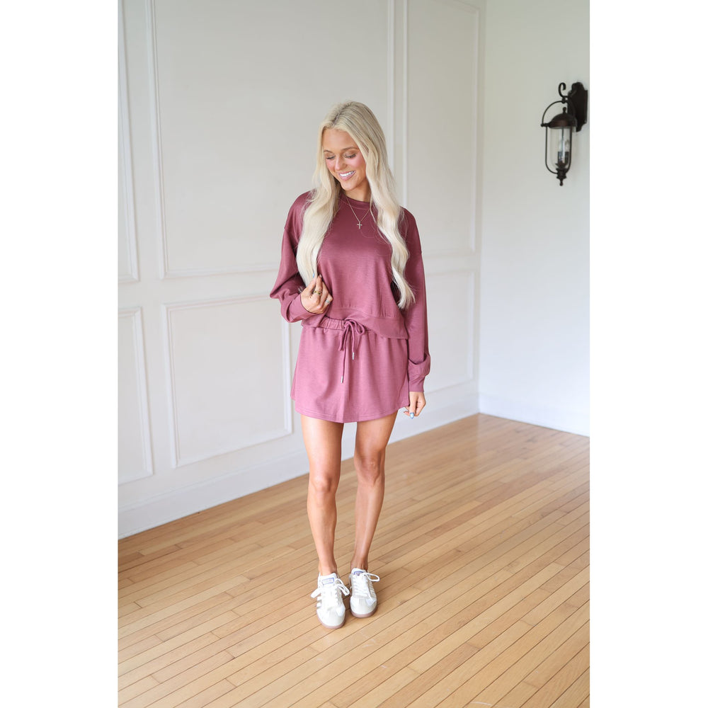 Woman wearing a pink sweatshirt and skirt