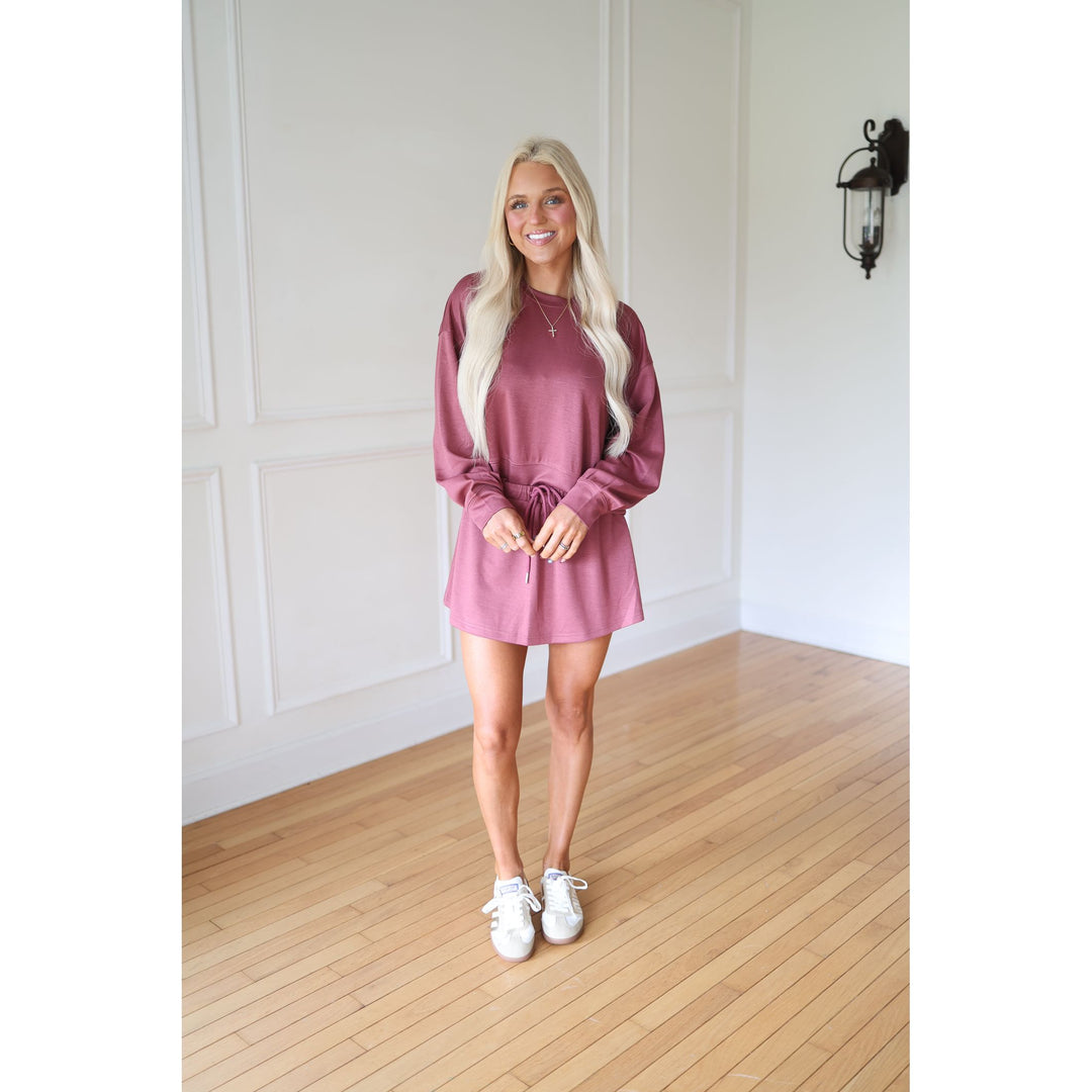 Woman wearing a pink sweatshirt and skirt