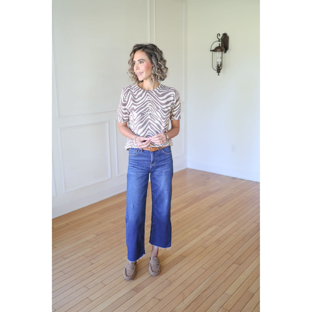 Woman wearing a zebra print shirt and blue jeans 