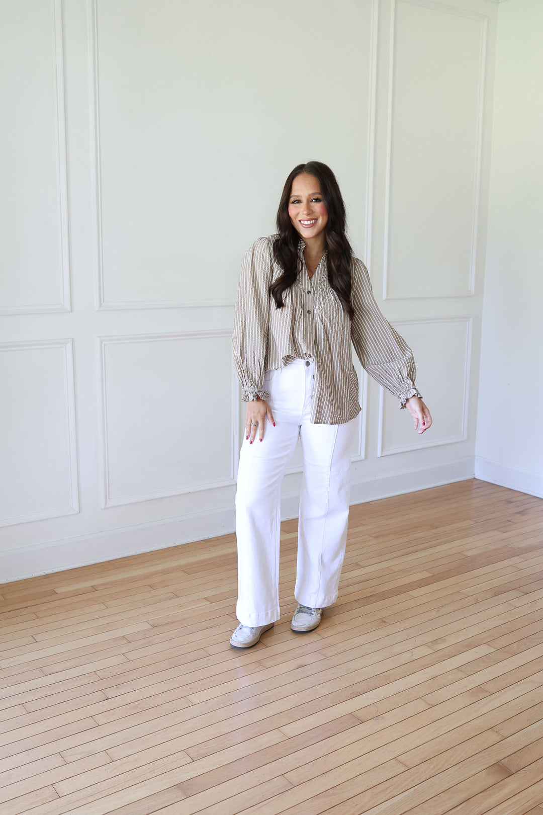 woman wearing white jeans and a striped top