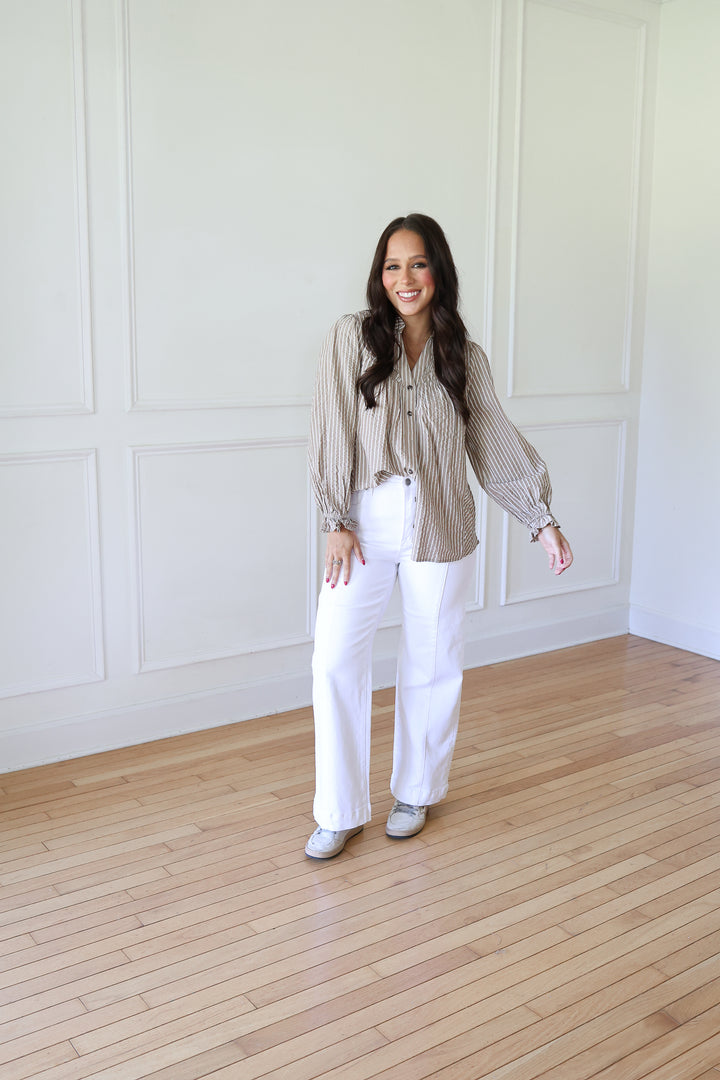 woman wearing white jeans and a striped top