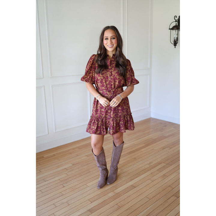 Woman wearing a red floral dress and gray knee-high boots 