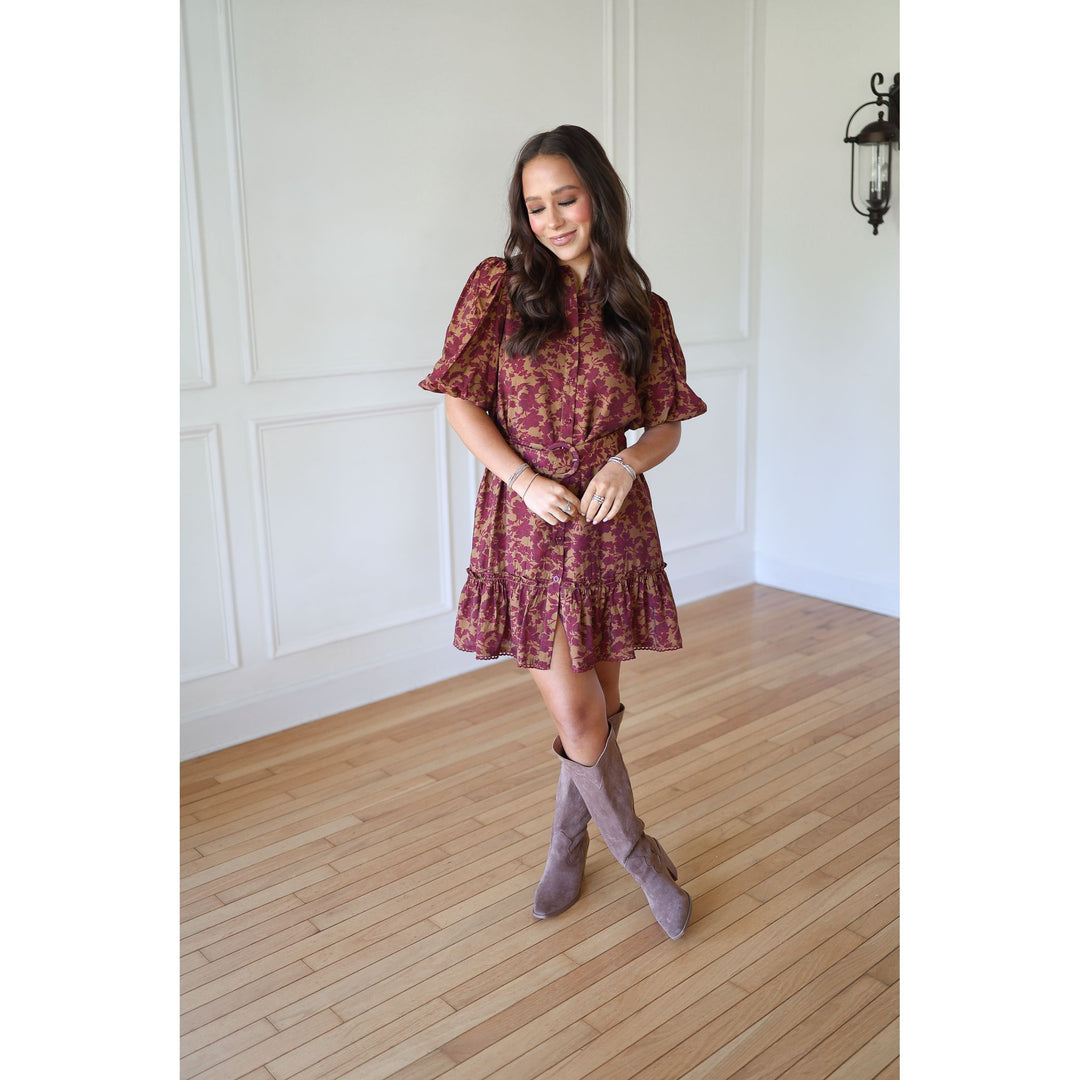 Woman wearing a patterned dress and knee-high boots 