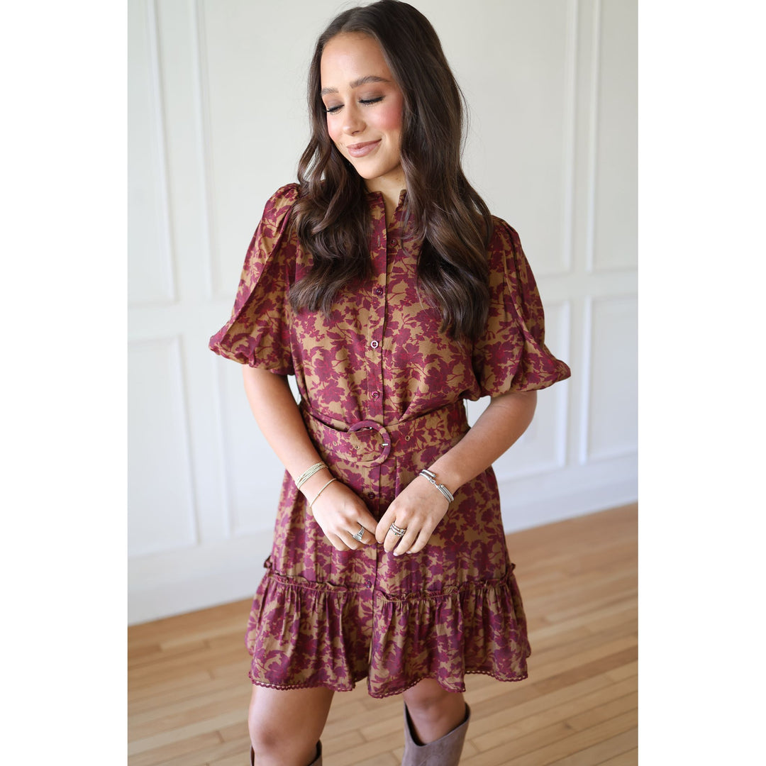 Woman wearing a maroon floral dress with ruffled sleeves and hem