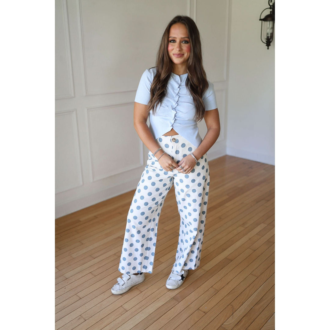 Woman wearing a light blue top and white pants with blue polka dots