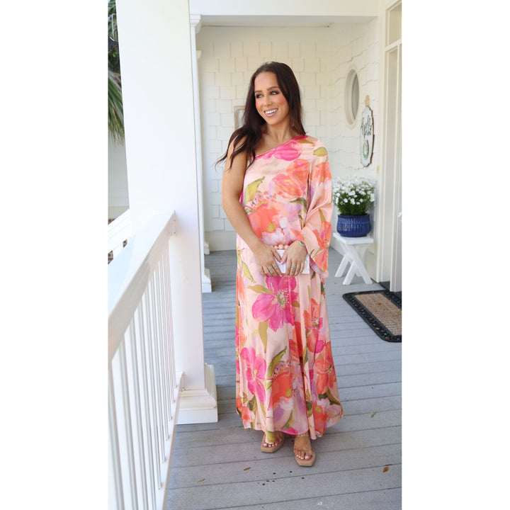 Woman in a floral dress standing on a porch