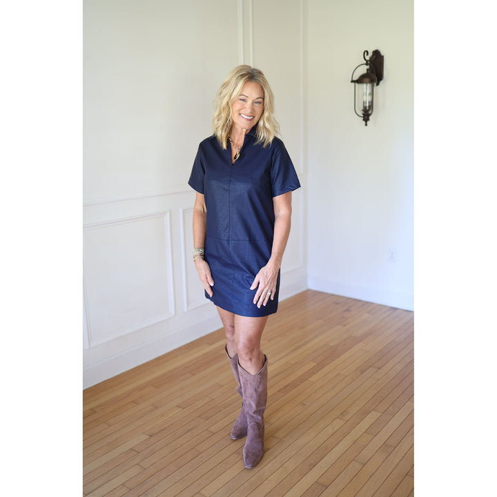 Woman wearing a navy dress and brown knee-high boots 