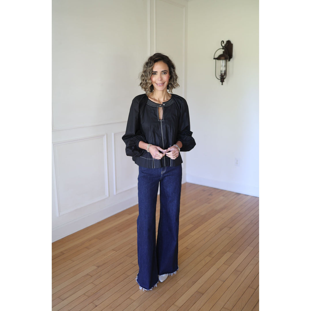 Woman wearing a black top and blue jeans 